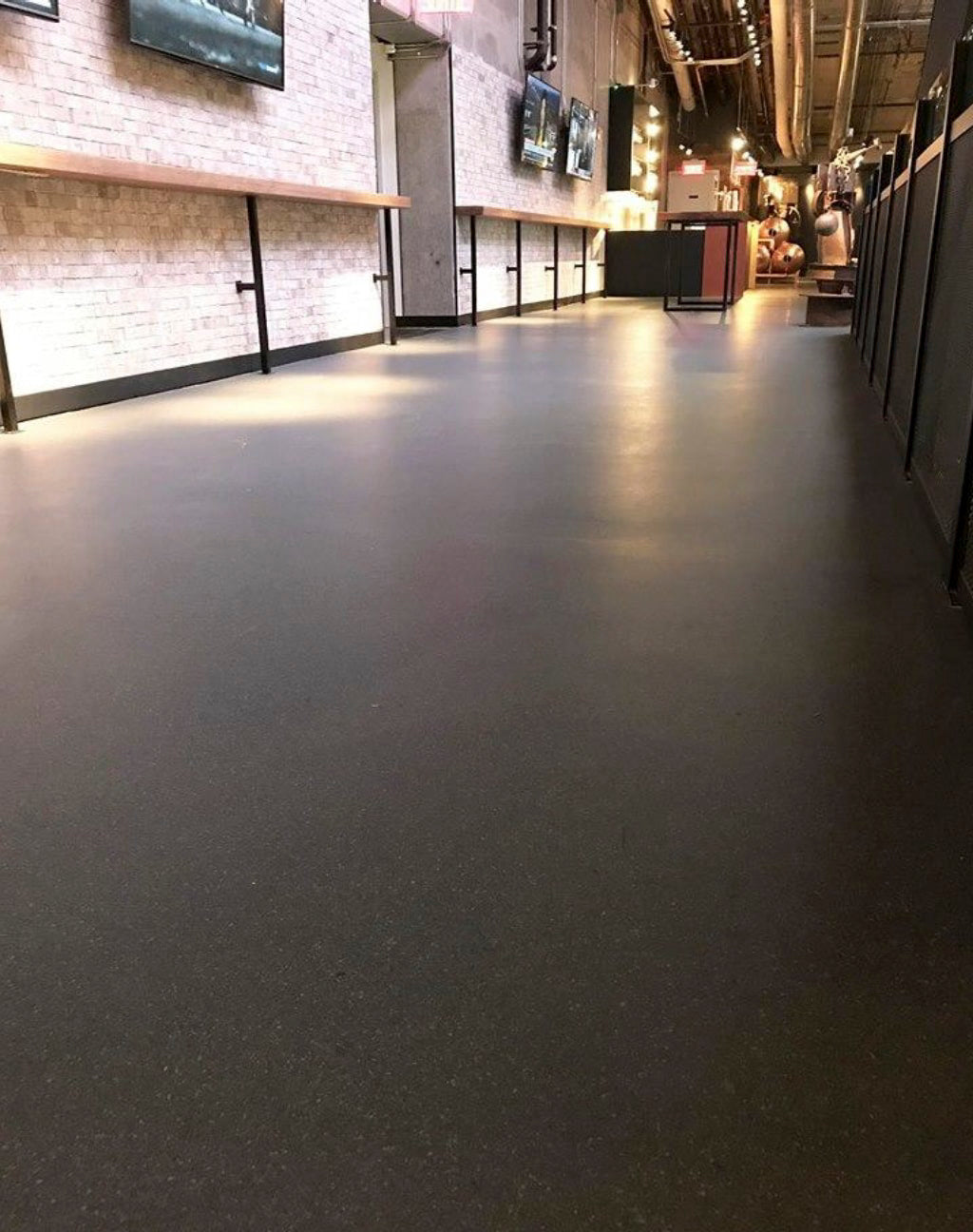 Modern commercial restaurant hallway with a gray concrete floor protected by AQUALAB PUR Matte water-based urethane for a durable, non-reflective finish.