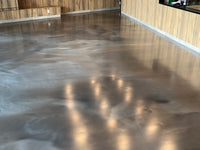 Thumbnail for Metallic epoxy floor with a smooth satin urethane topcoat in a modern interior with wood wall accents.