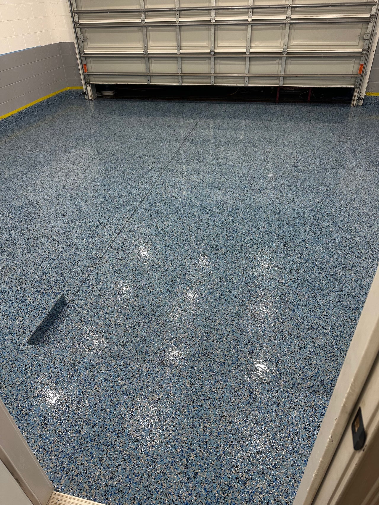 High-gloss full broadcast blue flake garage floor with a seamless, durable finish and a protective UV-resistant topcoat.