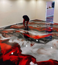 Thumbnail for High-gloss metallic epoxy floor design featuring a custom black, red, and silver color palette achieved with a premium self-leveling resin foundation