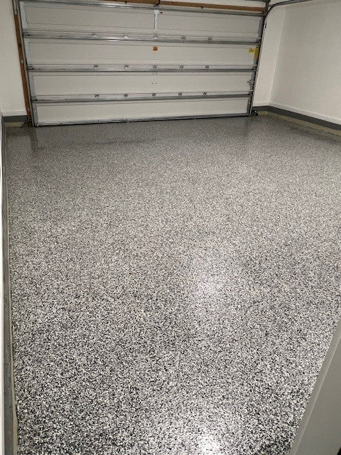 Stain-resistant domino flake garage floor finished with Poly Gloss 85 for a long-lasting, easy-to-clean surface