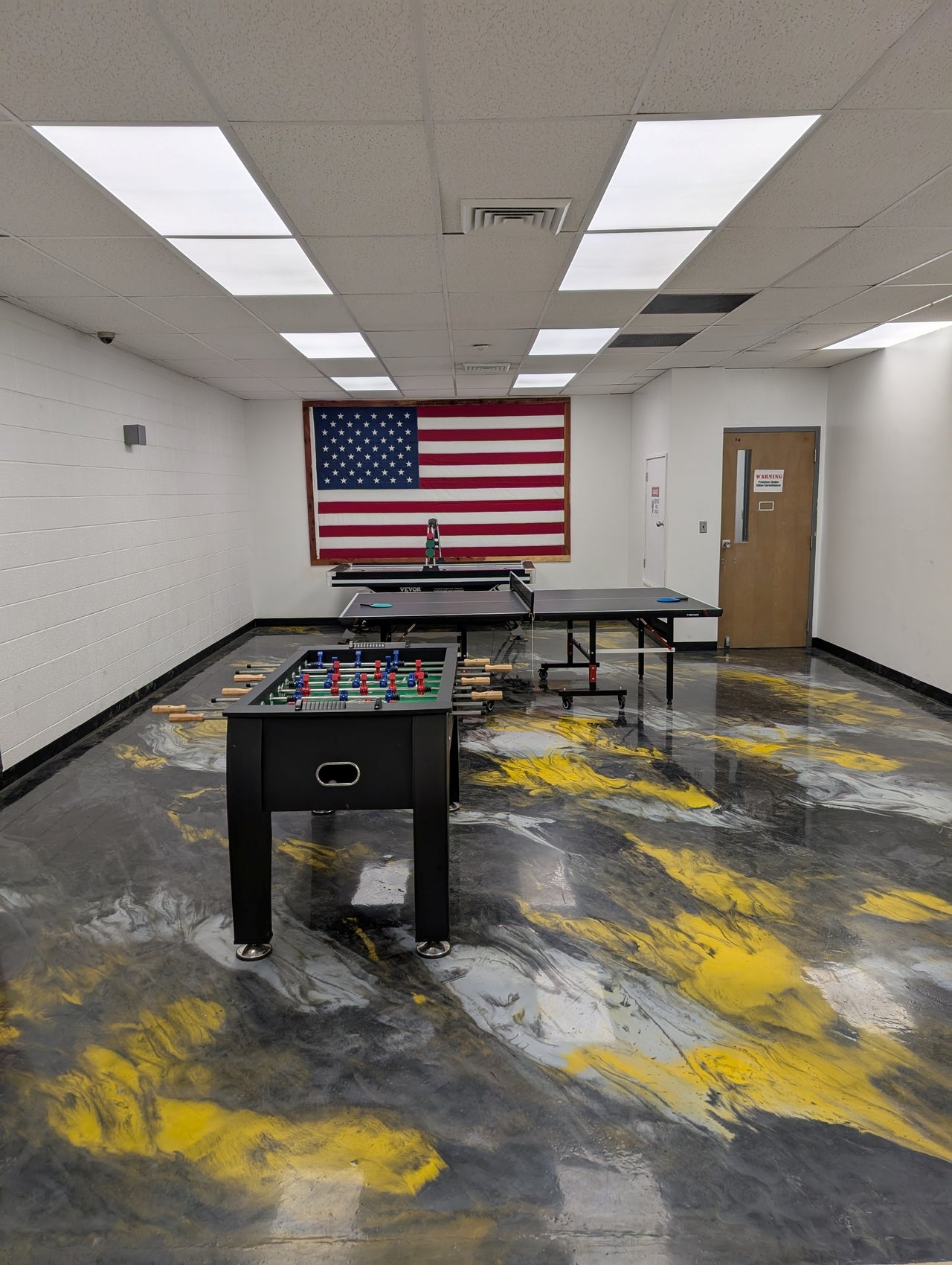 Designer game room floor featuring a gold, silver, and black metallic design in a high-gloss, self-leveling 100% solids epoxy finish