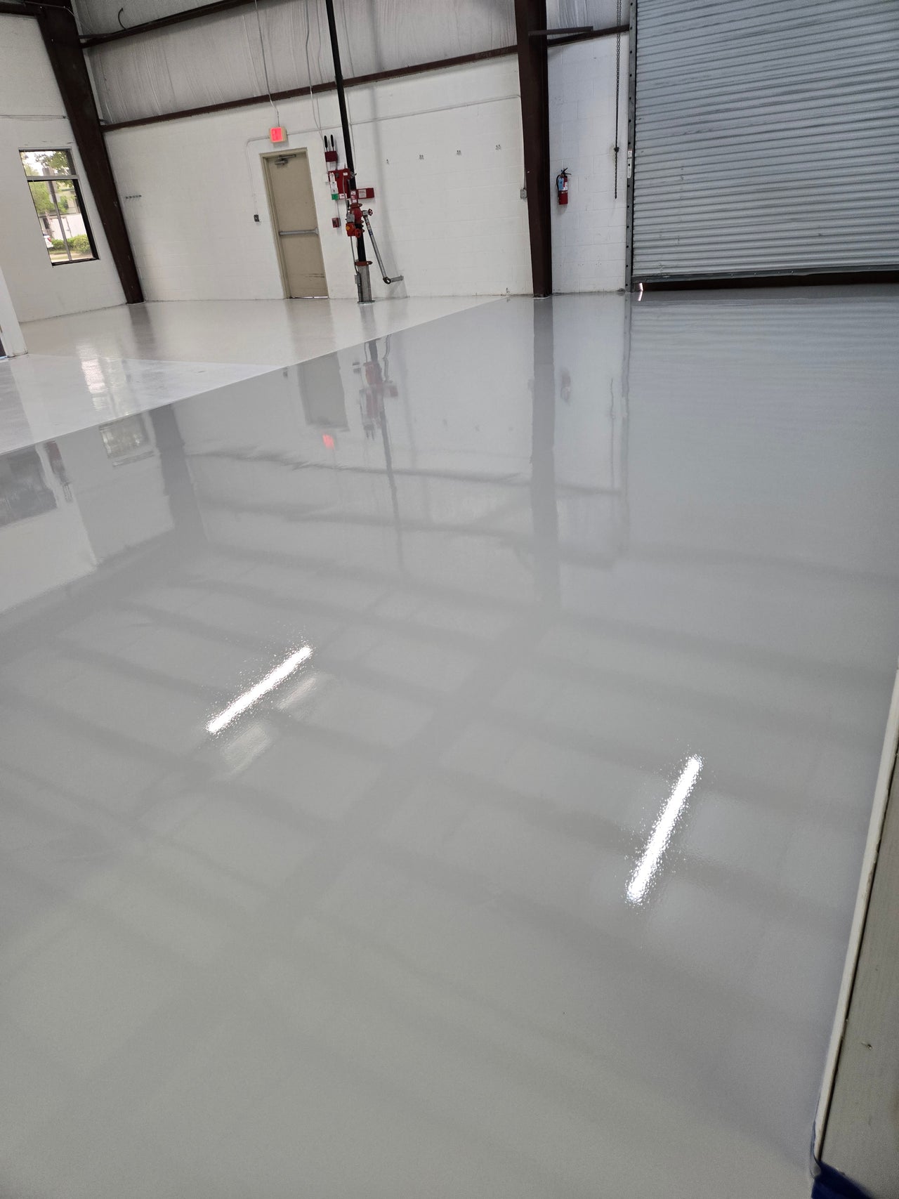 Light Gray self-leveling industrial grade 100% solids epoxy floor coating installed in a large commercial warehouse.