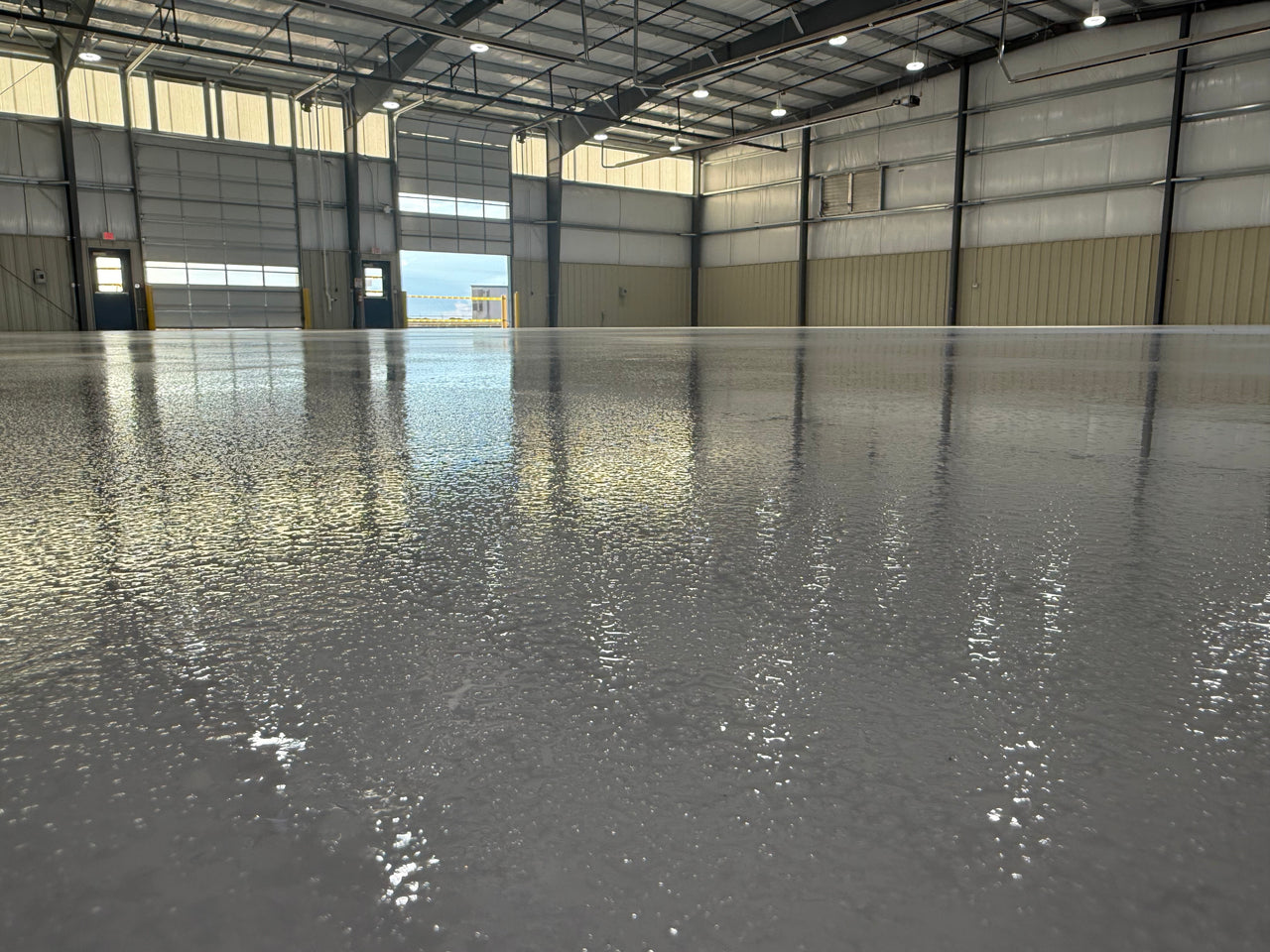 Large industrial warehouse with a high-gloss, light-reflective floor using LABFENDER Aliphatic Polyurethane for superior abrasion and chemical resistance.