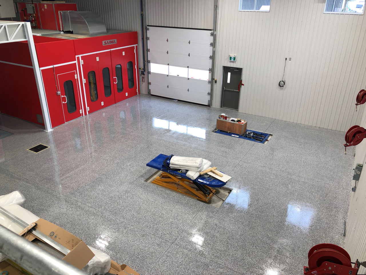 Large commercial garage floor finished with Labfast 85 (+) polyaspartic and a full broadcast flake system for a durable, high-gloss, and chemical-resistant surface.