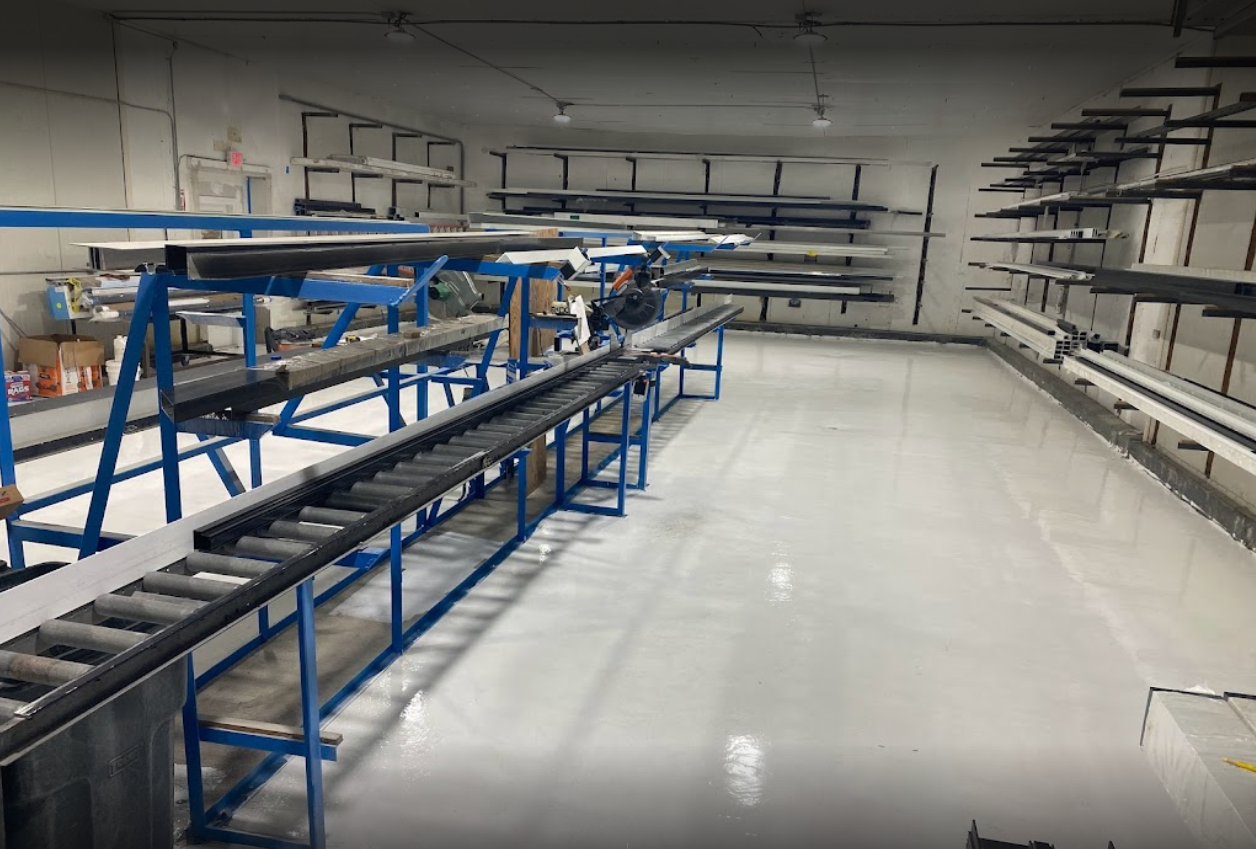 High-gloss white Labpox 35 100% solids epoxy floor coating installed in a large industrial warehouse with shelving and conveyors.