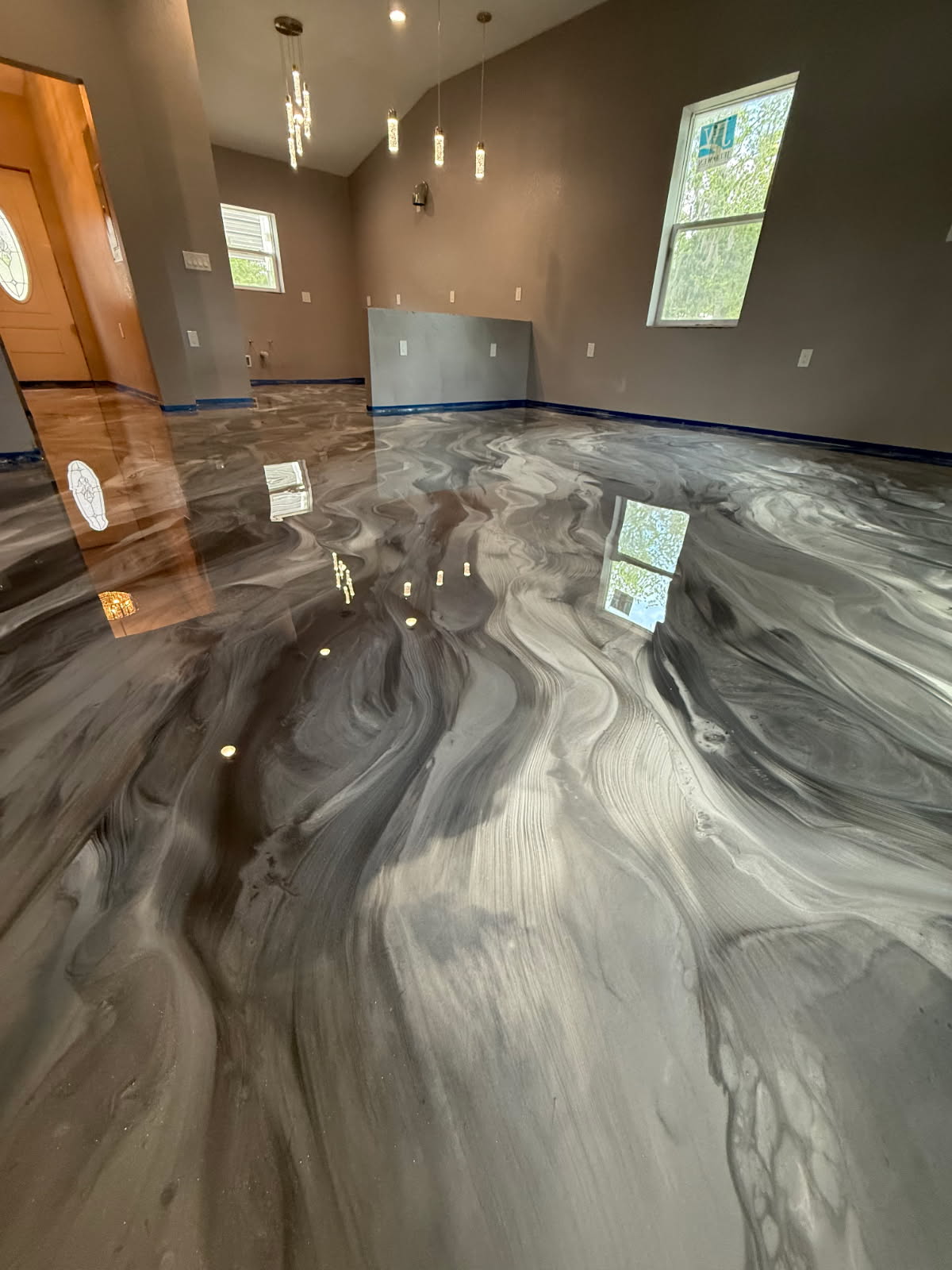 Minimalist home living space featuring a custom gray metallic floor with subtle silver veining and a high-gloss topcoat.