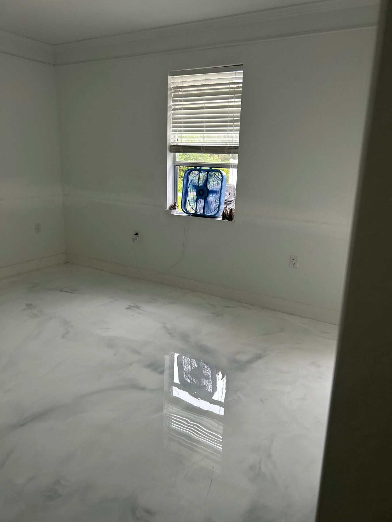 Seamless high-gloss white and gray marble effect epoxy floor in a contemporary residential living space.