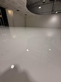 Thumbnail for Large commercial showroom featuring a seamless, high-gloss white metallic epoxy floor with a reflective finish using LABPOX 40 UV Resistant Epoxy