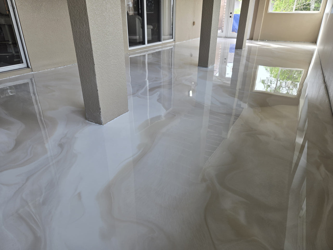 Residential interior featuring a seamless white and tan metallic epoxy floor with a high-gloss marble effect using LABPOX 40.