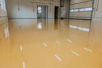 Thumbnail for Tan self leveling industrial grade epoxy application on a large commercial floor, providing a high-gloss and chemical-resistant surface.